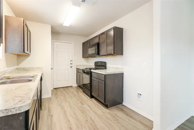 a kitchen with a sink cabinets and stainless steel appliances