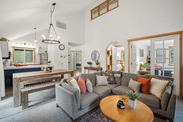 a living room with furniture a chandelier and a fireplace