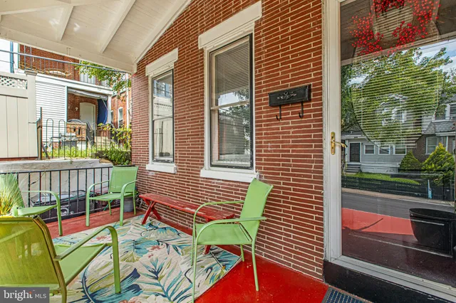 an empty room with wooden floor stairs and a chandelier fan