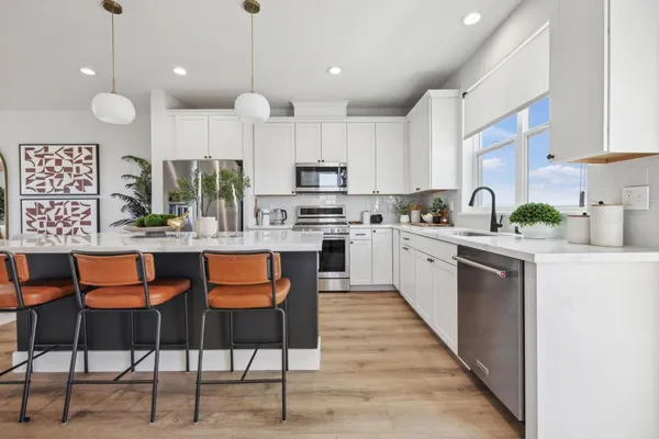 a kitchen with stainless steel appliances granite countertop a stove a sink a microwave a center island and a cabinets