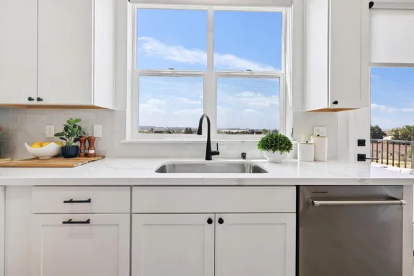 a kitchen with stainless steel appliances white cabinets and a window