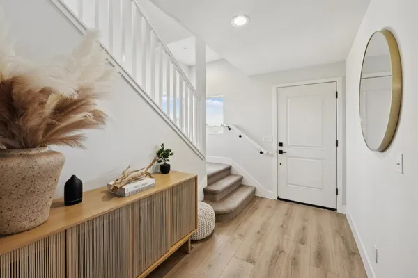 a view of a livingroom with wooden floor and stairs