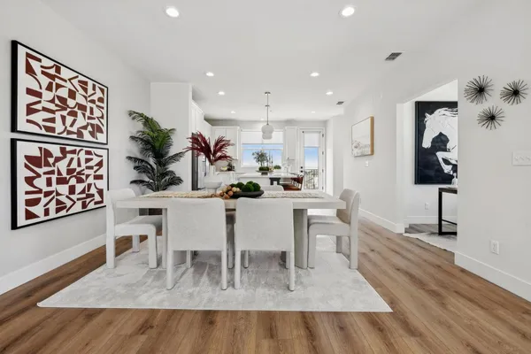 a dining room with furniture and a painting on the wall