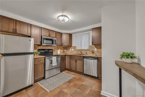 a kitchen with sink a microwave and refrigerator