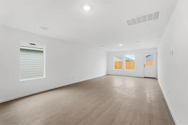 wooden floor in an empty room with a window