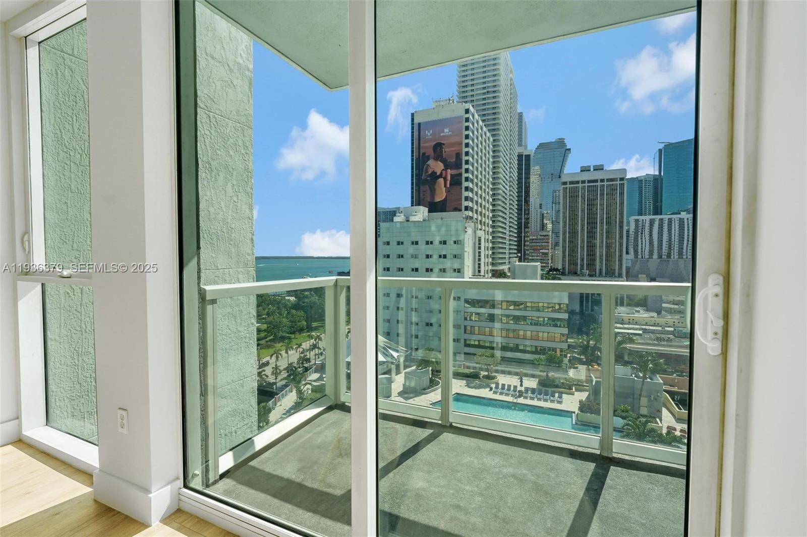 244 Biscayne Boulevard, Unit 1505 Miami, FL 33132 - Photo 17 of 25 a glass door with a tree in front of it
