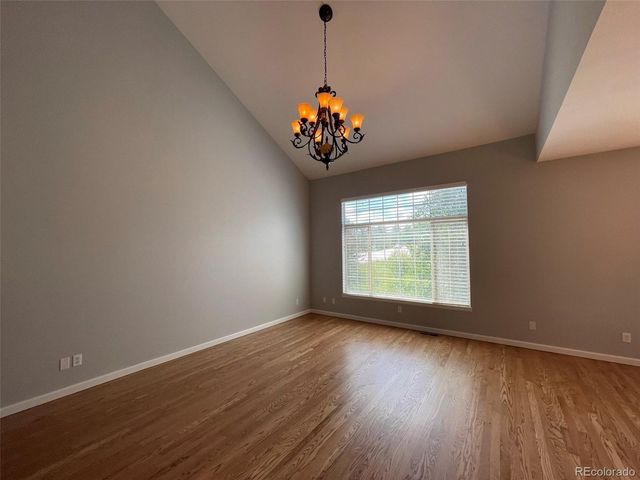 a view of a room with wooden floor and chandelier