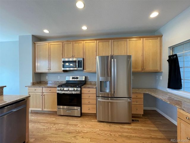 a kitchen with wooden cabinets and stainless steel appliances