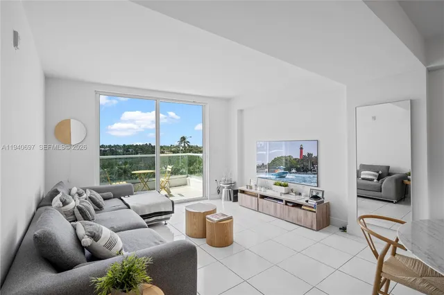 a living room with furniture and a floor to ceiling window