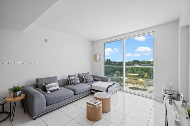 a living room with furniture and a floor to ceiling window