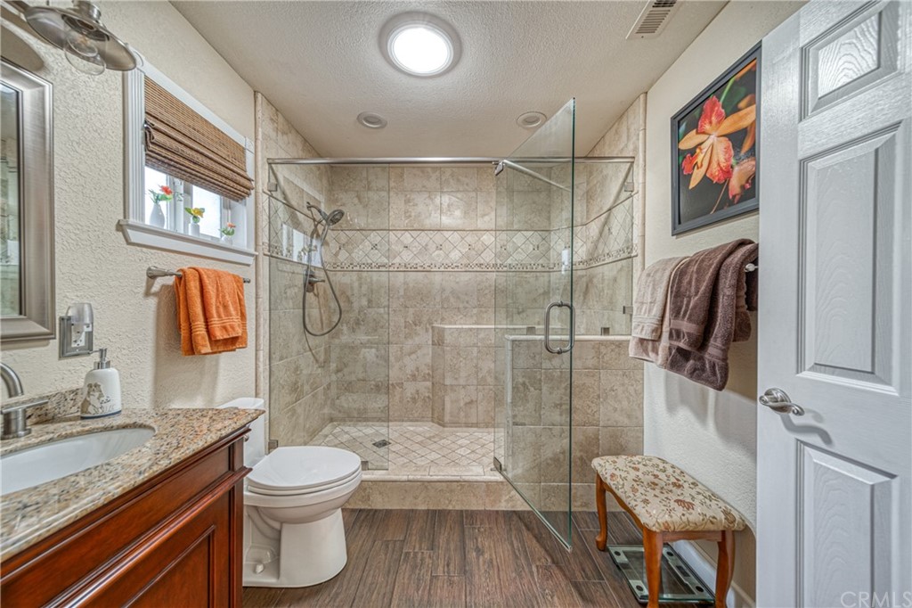 704 Miller Avenue Chico, CA 95928 - Photo 19 of 38 a bathroom with a granite countertop sink a toilet a shower and a mirror