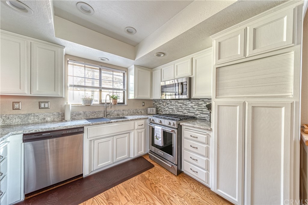 704 Miller Avenue Chico, CA 95928 - Photo 9 of 38 a kitchen with granite countertop cabinets stainless steel appliances a sink and a window