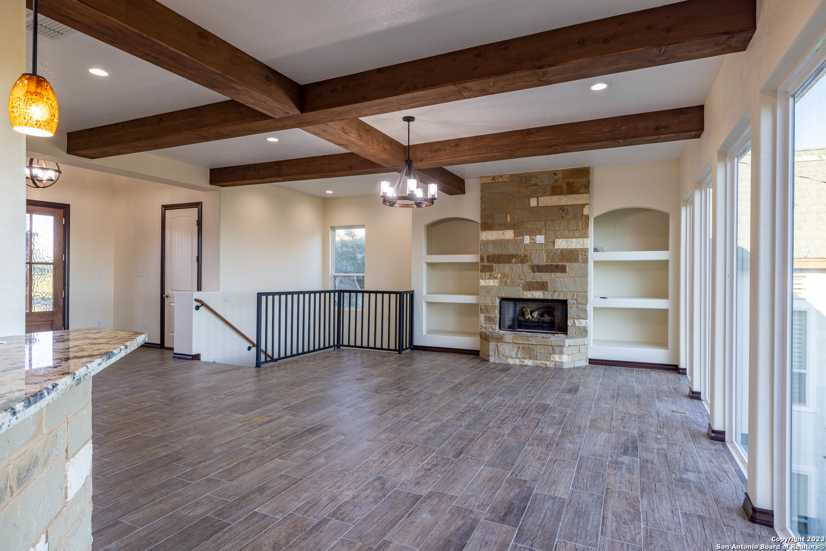 86 Hannah Lane Boerne, TX 78006 - Photo 14 of 45 an empty room with wooden floor fireplace and windows