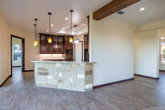 a view of kitchen with stainless steel appliances granite countertop cabinets and wooden floor