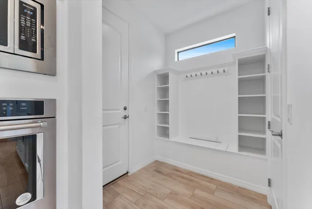 a view of an empty room with cabinet and wooden floor