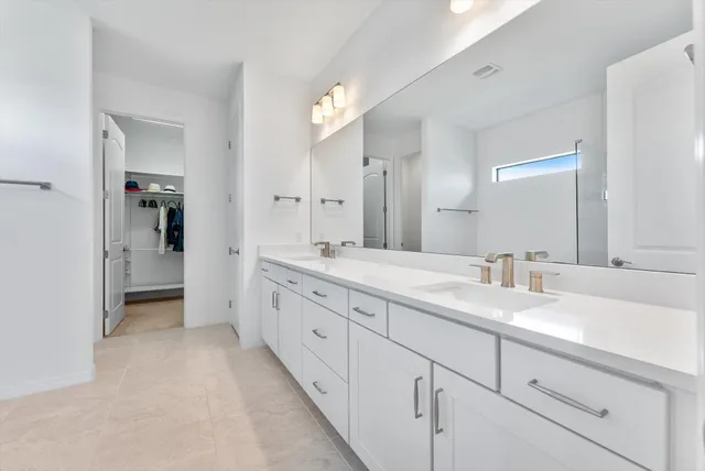 a spacious bathroom with a granite countertop sink mirror and a shower