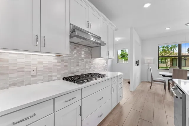 a kitchen with stainless steel appliances a white stove top oven and a white cabinets