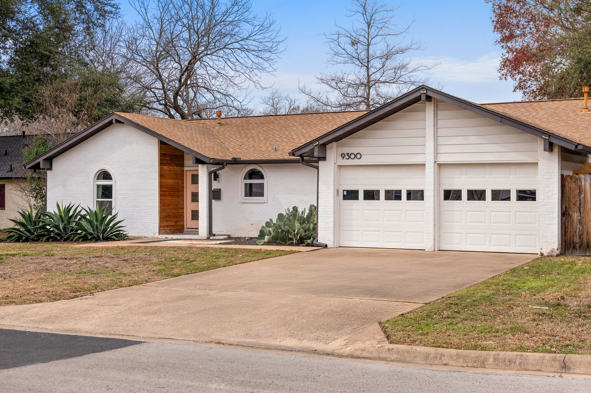Ranch-style home featuring brick siding, concrete driveway, an attached garage, and a shingled roof
