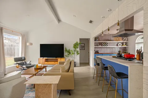 a work room with furniture a flat screen tv and a window