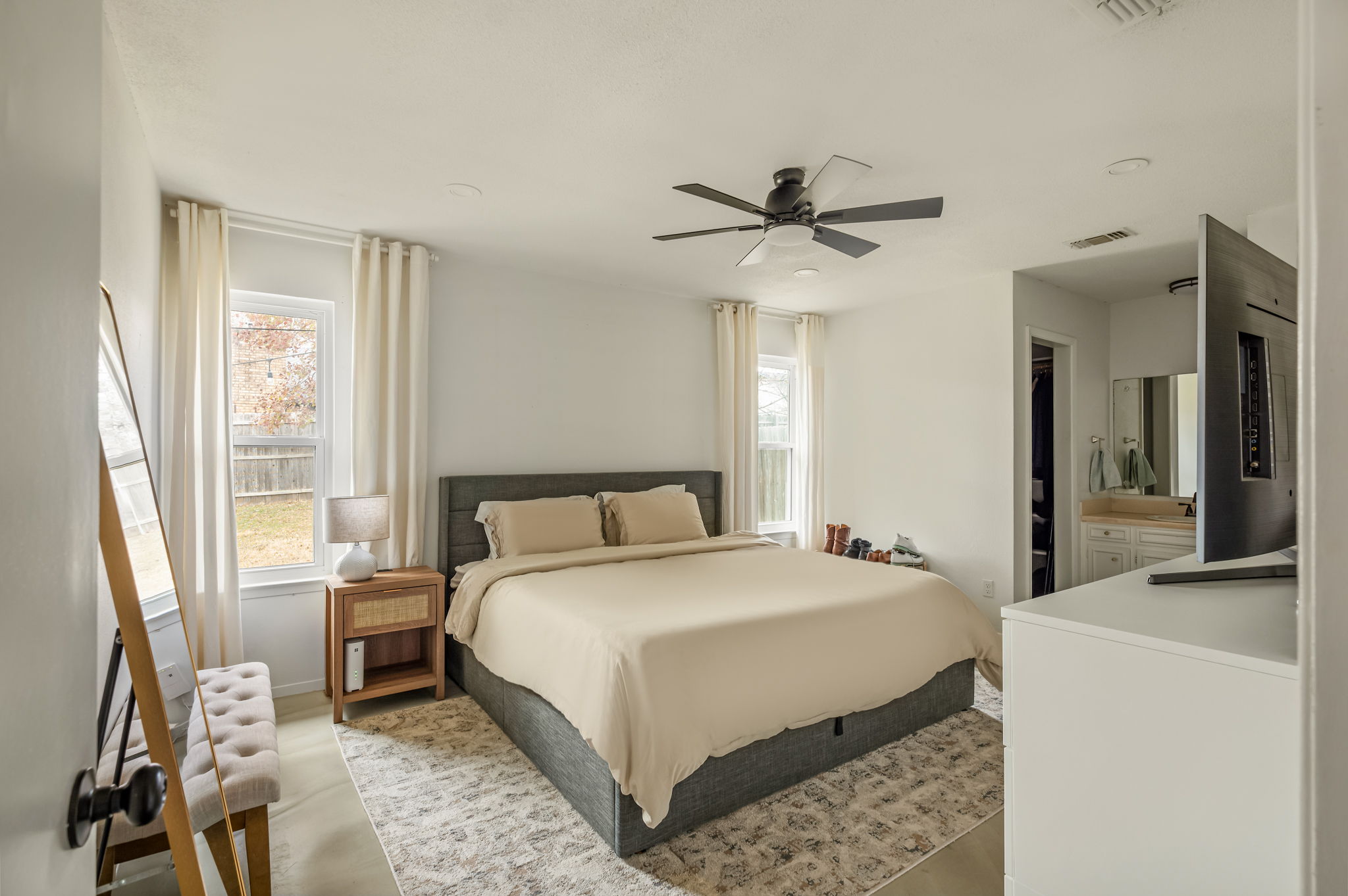 9300 Meadow Vale Austin, TX 78758 - Photo 22 of 37 Bedroom with multiple windows, a ceiling fan, and ensuite bath