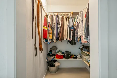 a view of walk in closet with clothes and shoes