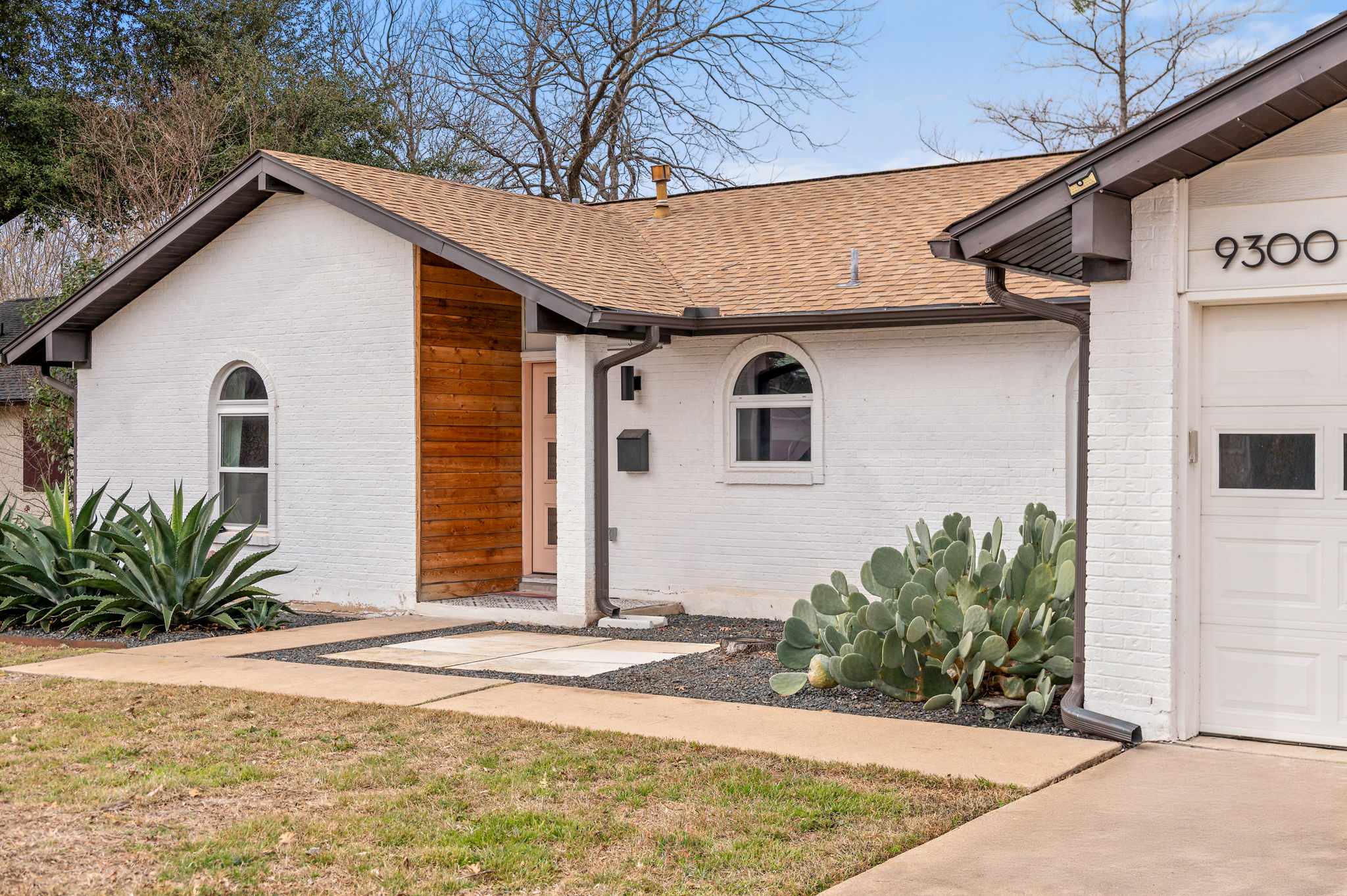 9300 Meadow Vale Austin, TX 78758 - Photo 36 of 37 View of exterior entry with a shingled roof, brick siding, and a lawn