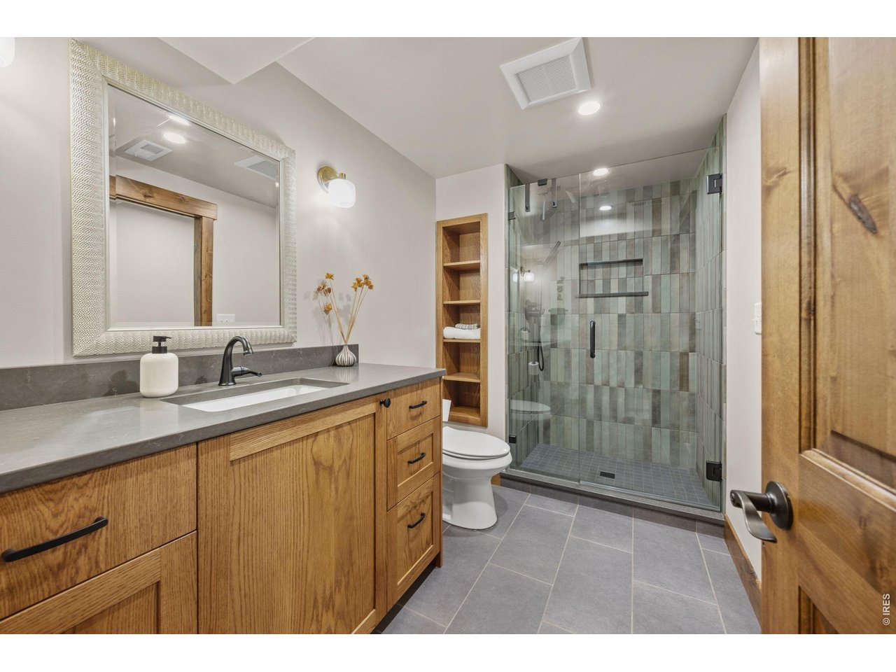 621 Wood Street Fort Collins, CO 80521 - Photo 32 of 50 a bathroom with a granite countertop sink a mirror a toilet and shower