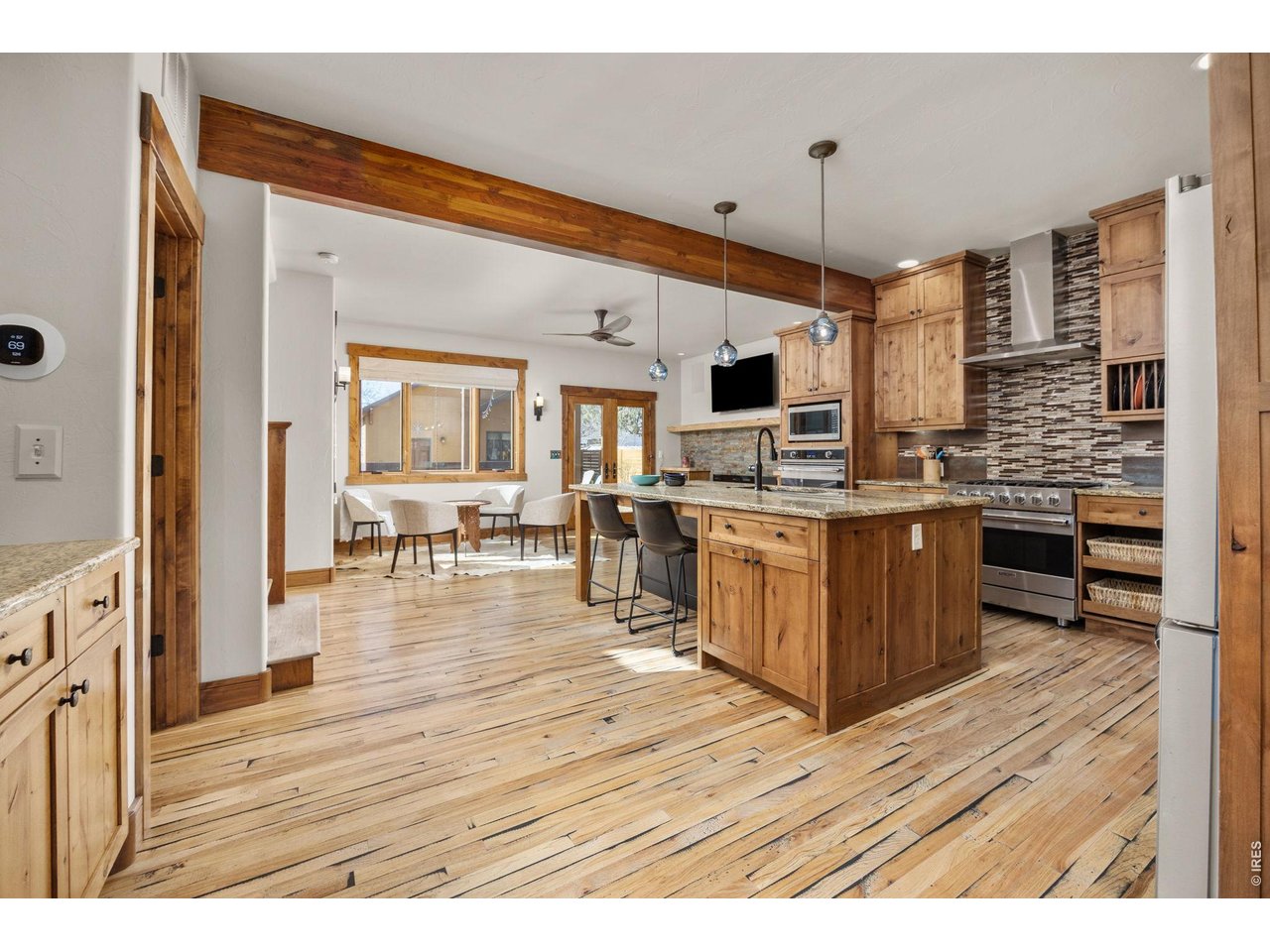 621 Wood Street Fort Collins, CO 80521 - Photo 8 of 50 a open kitchen with stainless steel appliances kitchen island granite countertop a stove top oven a sink dishwasher and cabinets with wooden floor