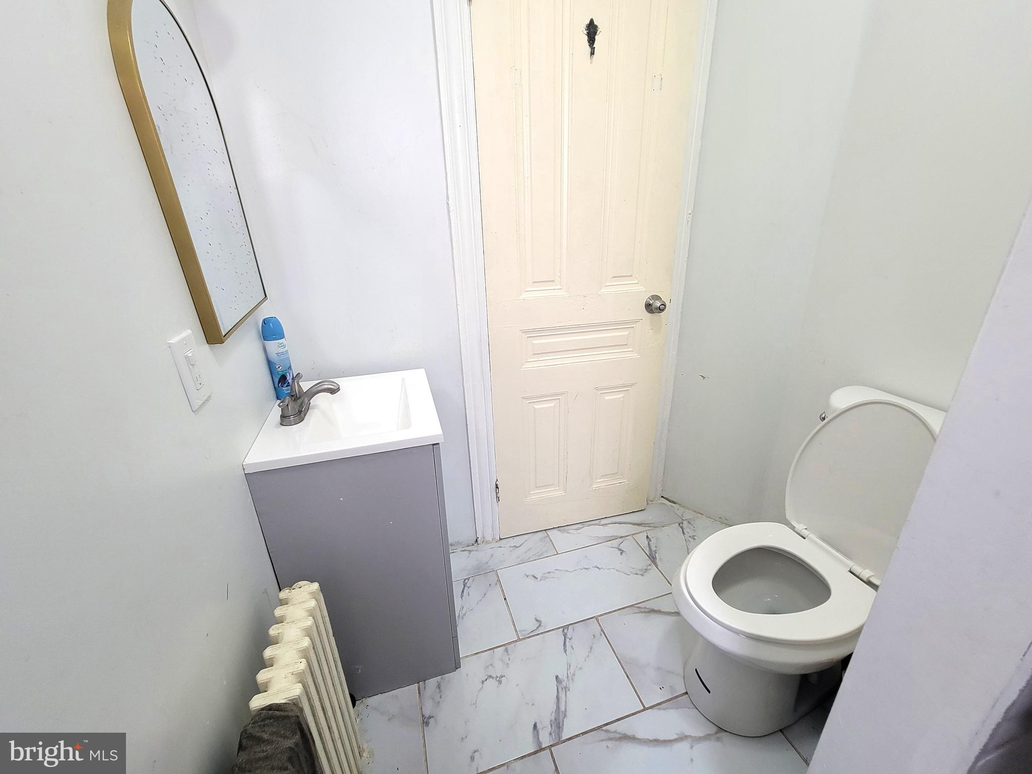 21 South 3rd Street Reading, PA 19602 - Photo 14 of 20 a white toilet sitting next to a sink and vanity