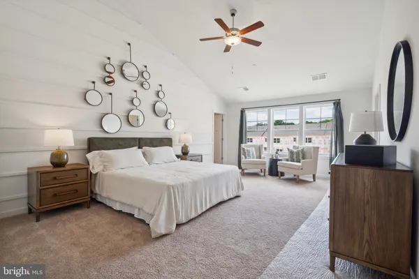 a bedroom with a bed couch and a window