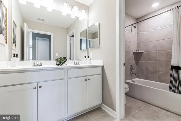 a bathroom with a double vanity sink mirror double and bathtub