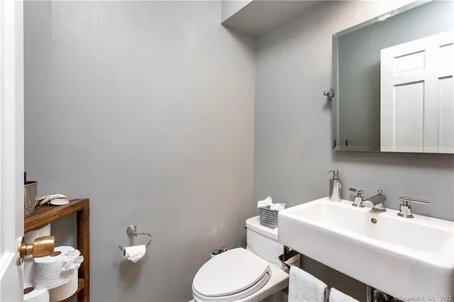 a bathroom with a sink a toilet and a mirror