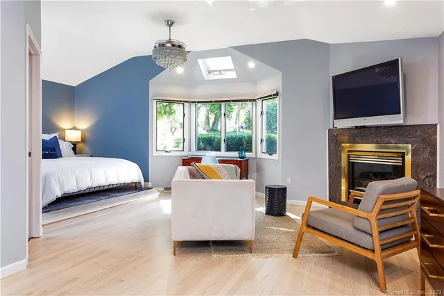 a bedroom with a bed a flat screen tv and a fireplace