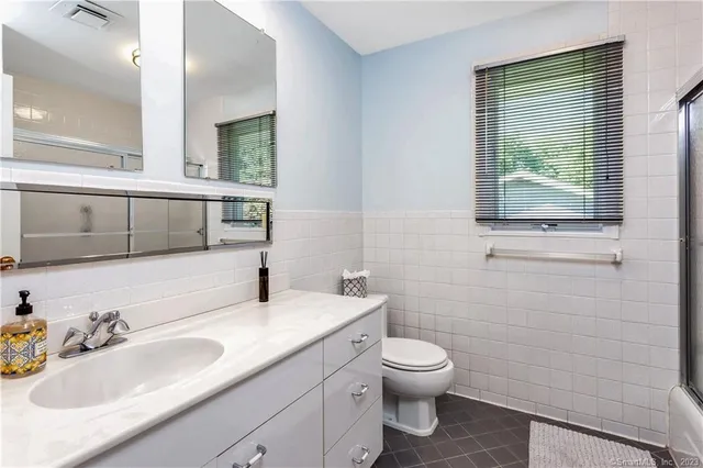 a bathroom with a toilet sink and mirror