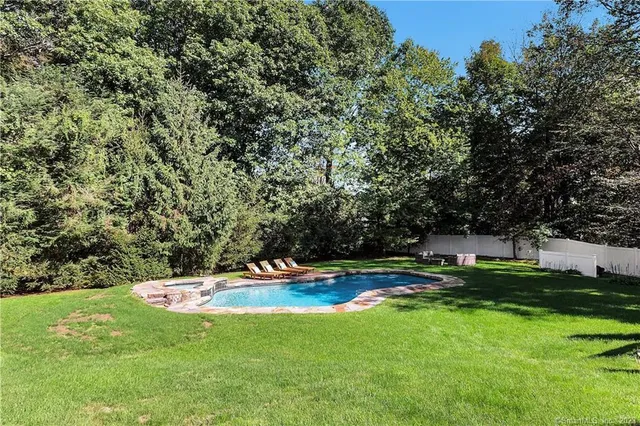 a swimming pool with outdoor seating and yard