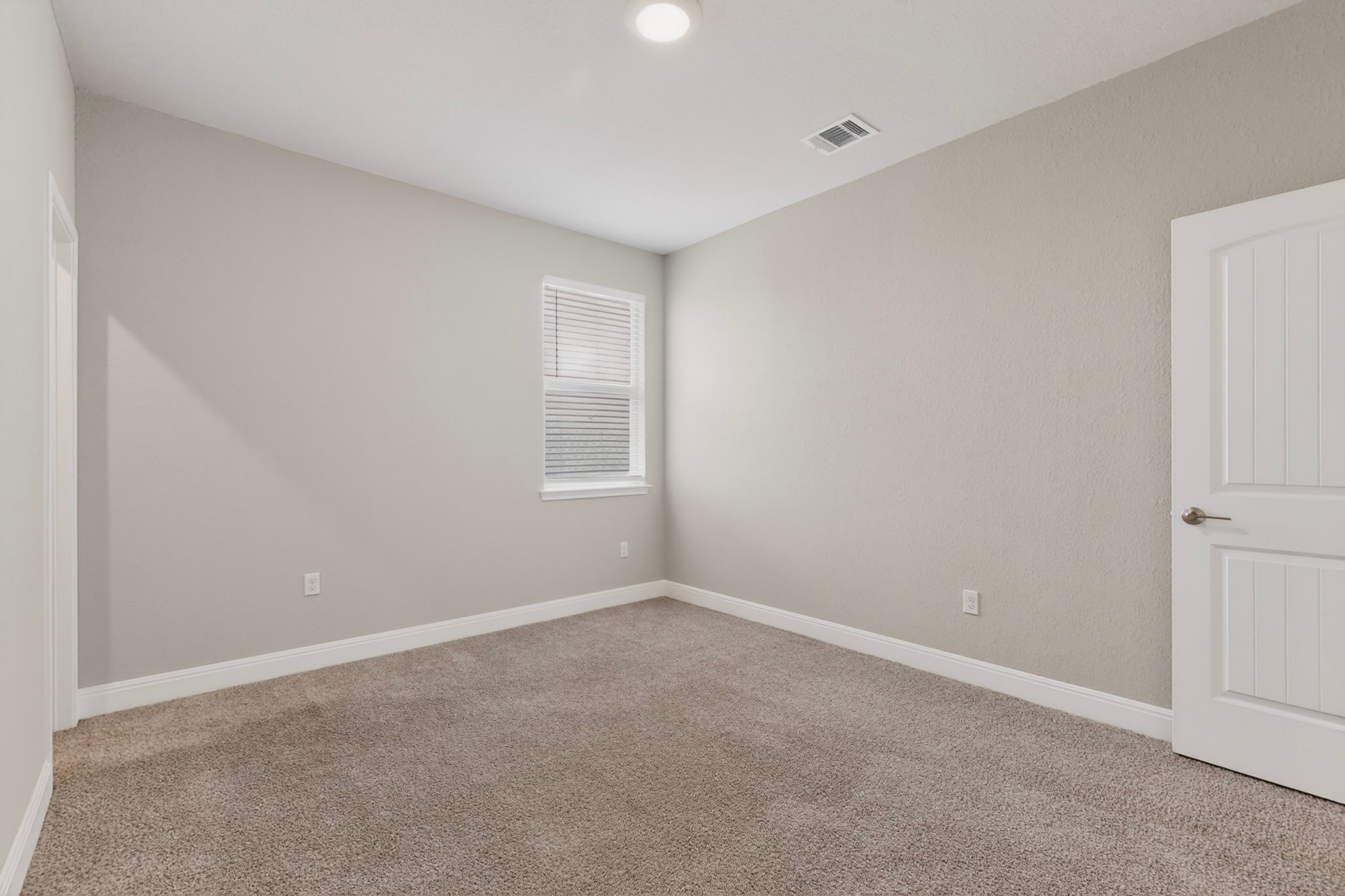 16809 Guido Cove Pflugerville, TX 78660 - Photo 27 of 40 Carpeted interior room featuring light-colored walls, white baseboards, a single window with blinds, and a white paneled door