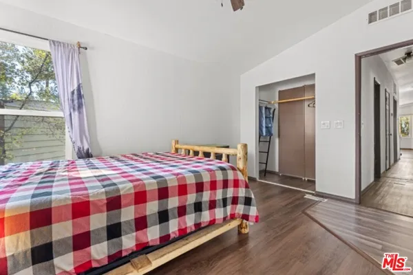 a bedroom with a bed and wooden floor