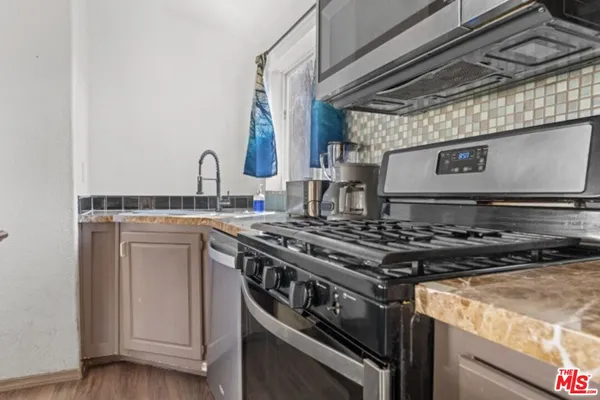 a stove top oven sitting inside of a kitchen