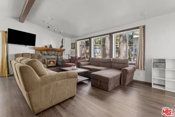a living room with furniture a flat screen tv and a fireplace