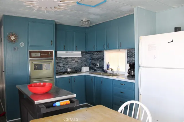 a kitchen with stainless steel appliances a stove a refrigerator and a sink