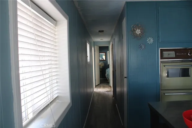 a view of a hallway with wooden floor and a living room