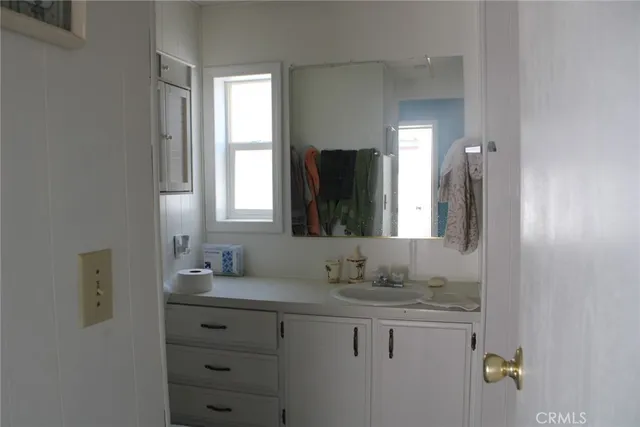 a bathroom with a granite countertop sink and a mirror
