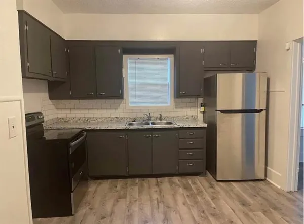 a kitchen with a refrigerator and cabinets