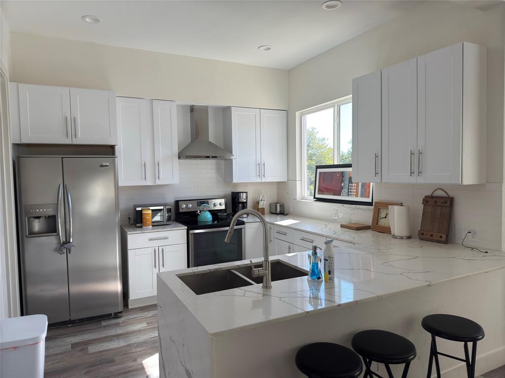 9497 Timberleaf Drive Dallas, TX 75243 - Photo 6 of 10 a kitchen with stainless steel appliances granite countertop a refrigerator a sink a stove and white cabinets