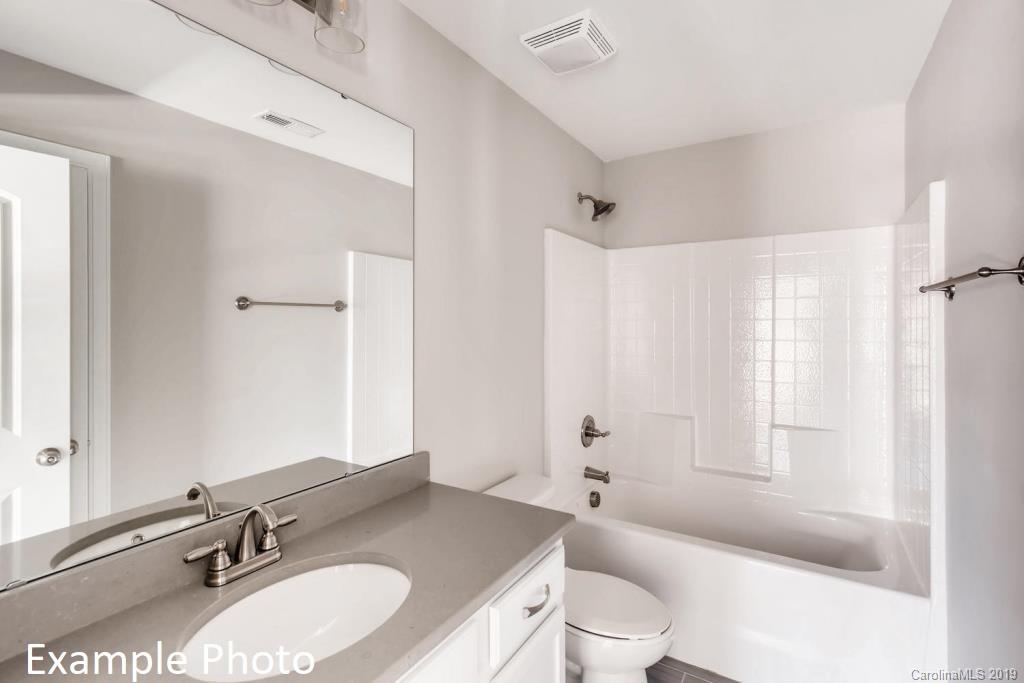 5148 Mill Creek Road, Unit 4 Clover, SC 29710 - Photo 3 of 12 a bathroom with a granite countertop tub sink toilet a mirror a vanity and shower