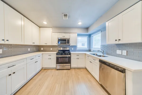 a kitchen with granite countertop white cabinets and white appliances