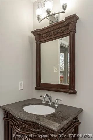 a bathroom with a granite countertop sink a mirror and vanity