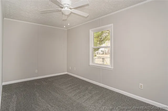 an empty room with a window and ceiling fan