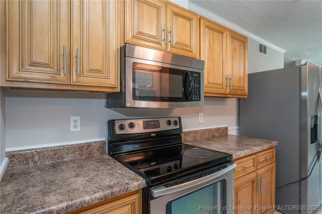 a kitchen with wooden cabinets and a stove top oven