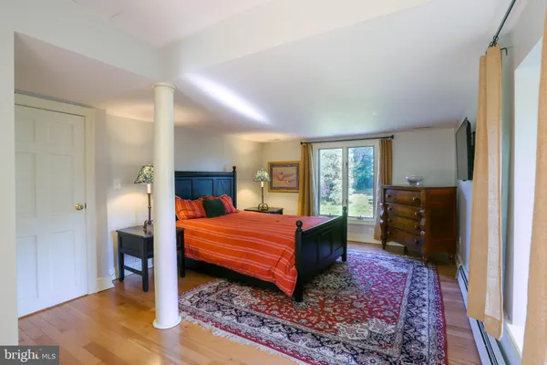 a bedroom with a bed and wooden floor